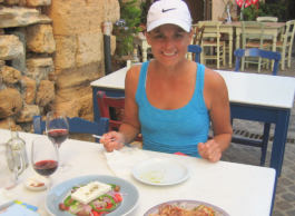 A woman enjoying a meal at a restaurant outdoors in Italy by a brick wall