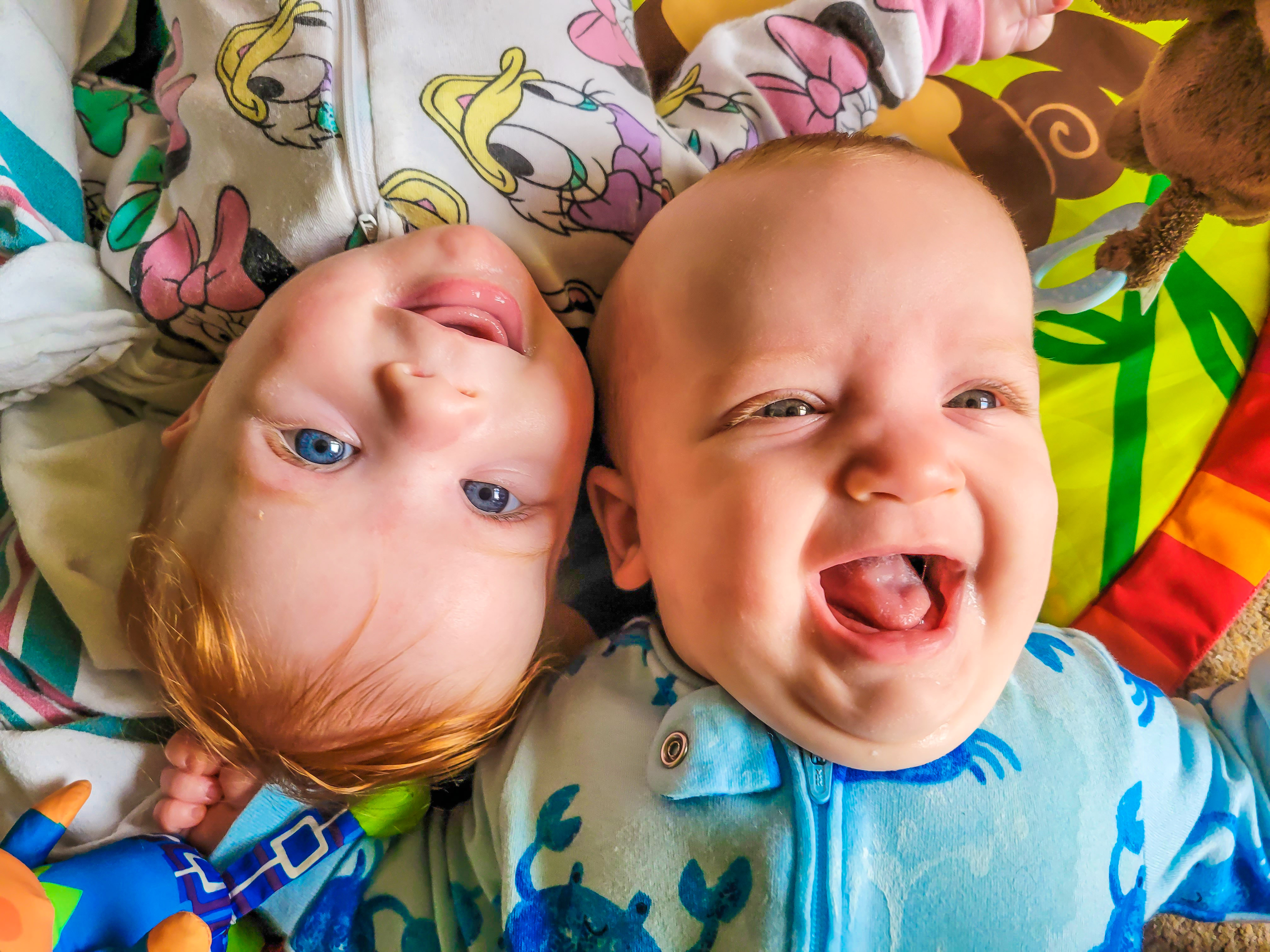 smiling infant twins who lay head to head