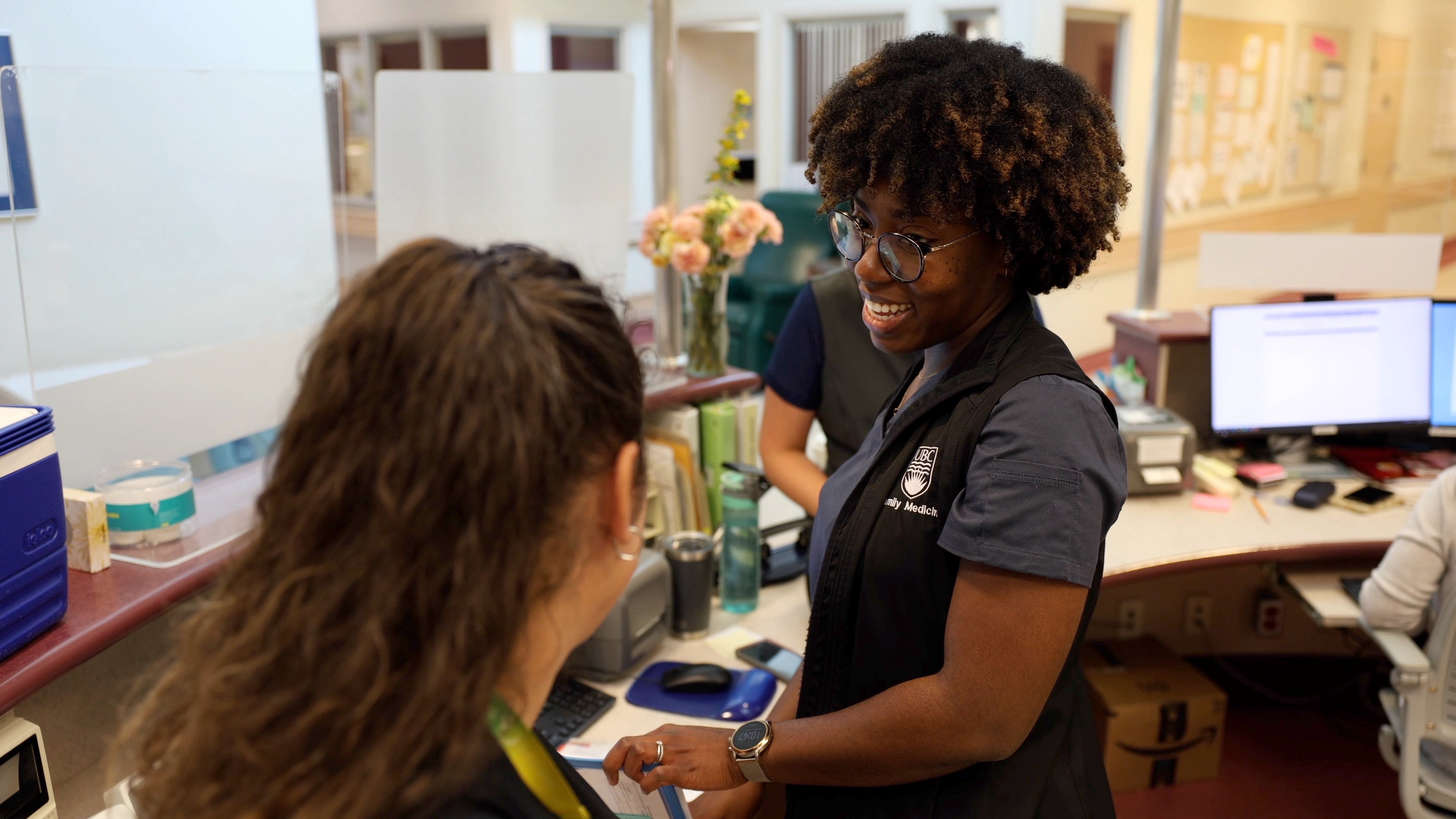 ""Nurse smiles while interacting with colleague