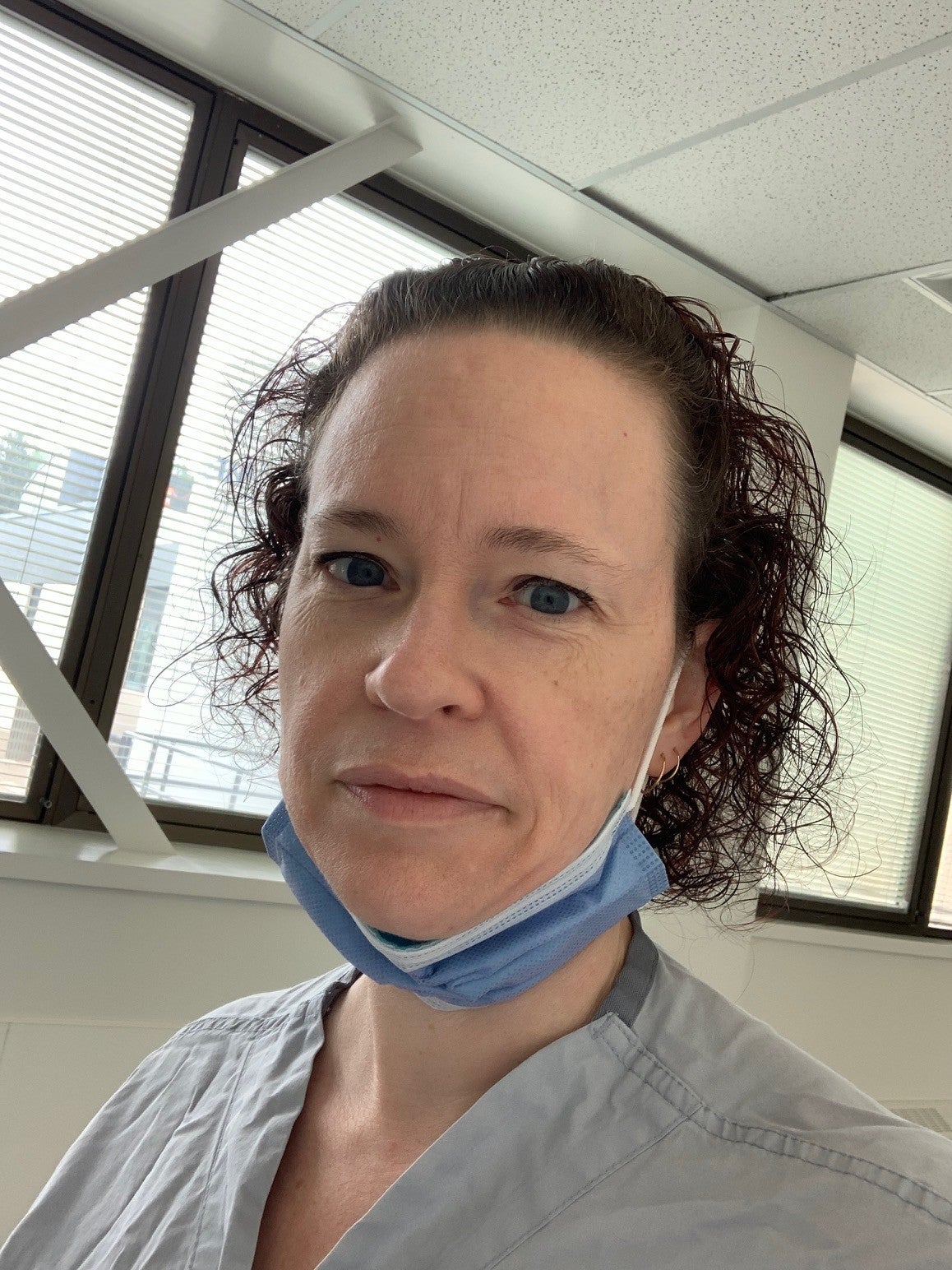 A person smiles while sitting at her desk.