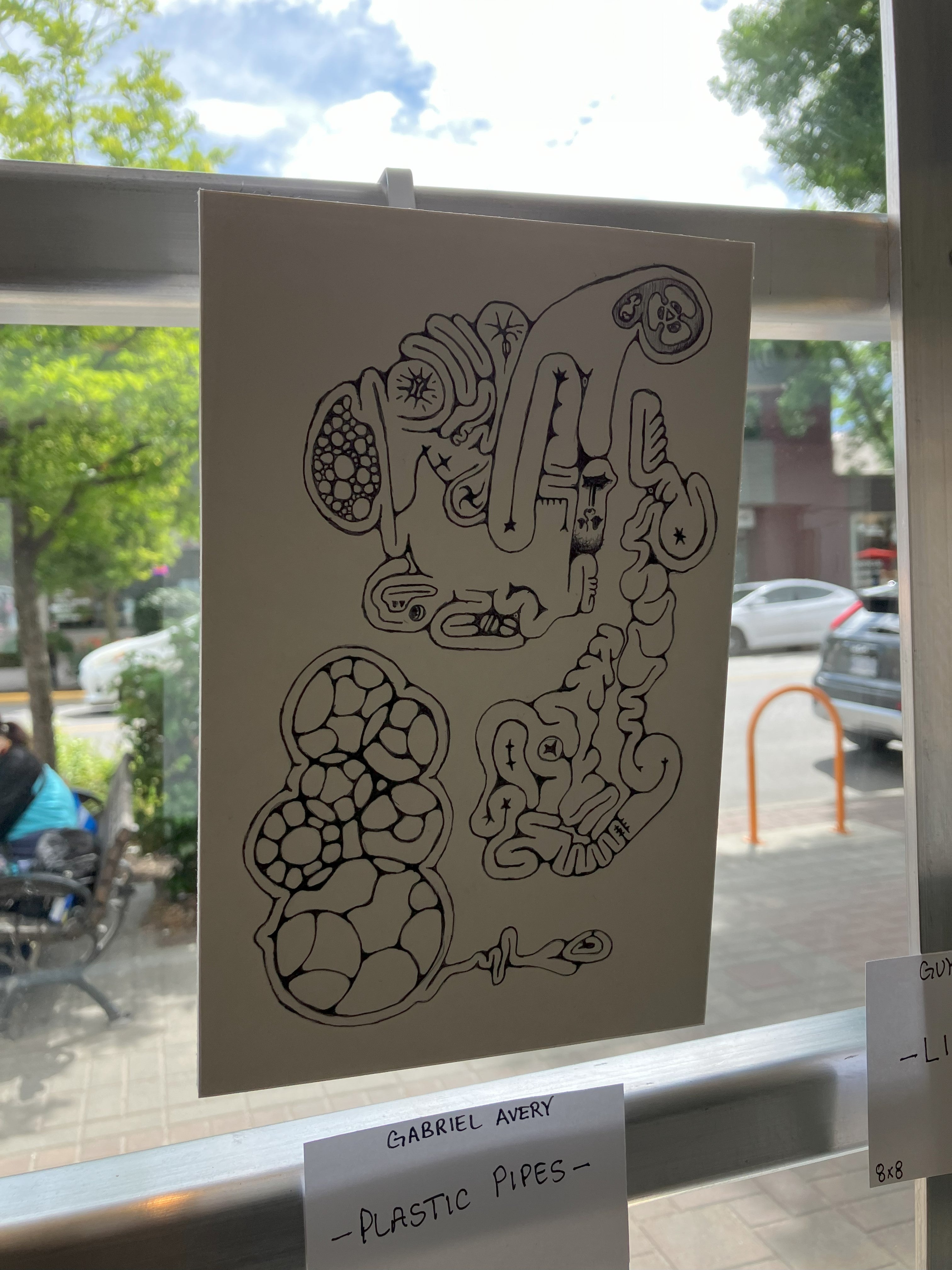 A black ink drawing on a white canvas depicting swirly organic shapes.