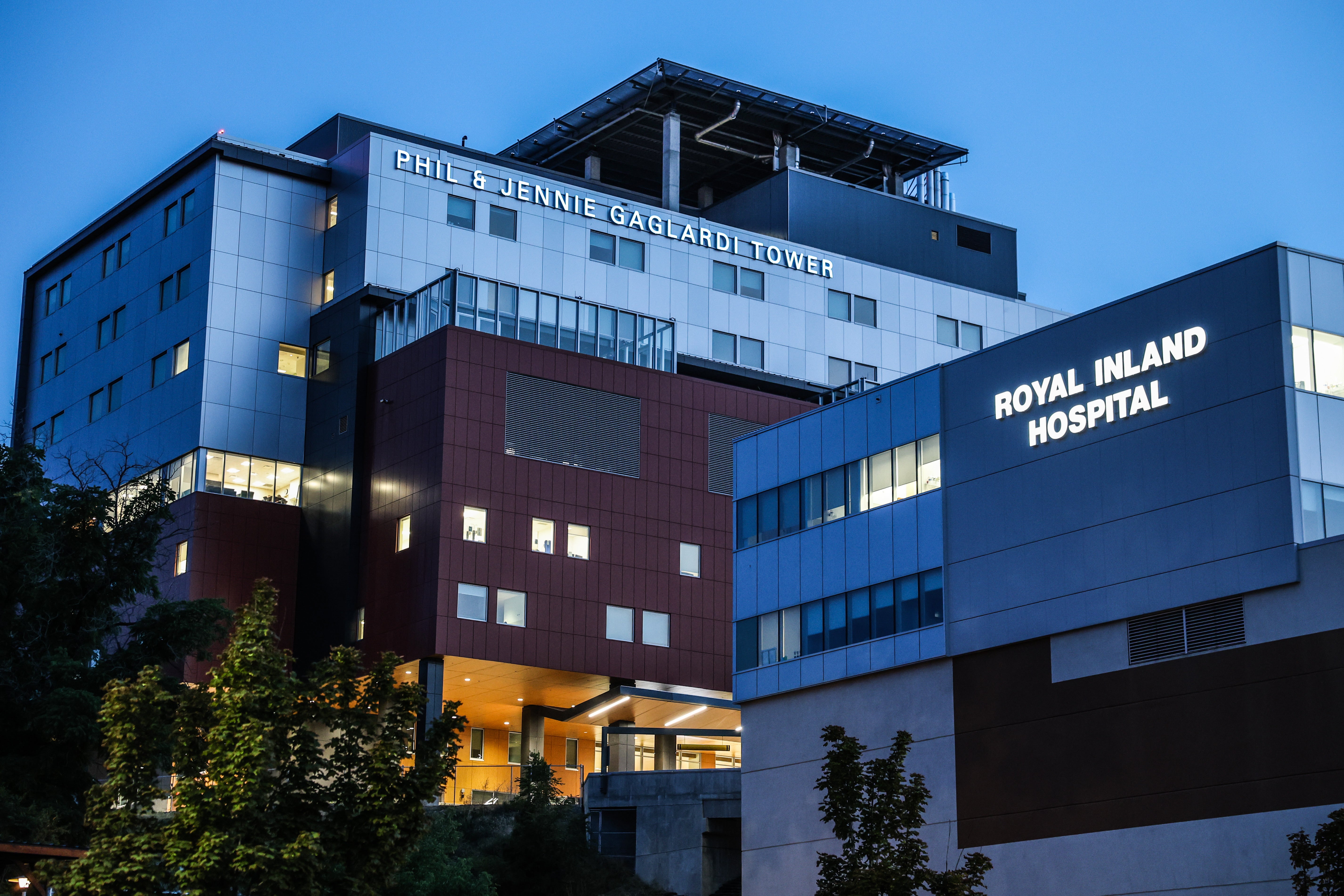 An exterior shot of two large buildings. The taller building has the words Phil & Jennie Gaglardi Tower written on it and the shorter one says Royal Inland Hospital.
