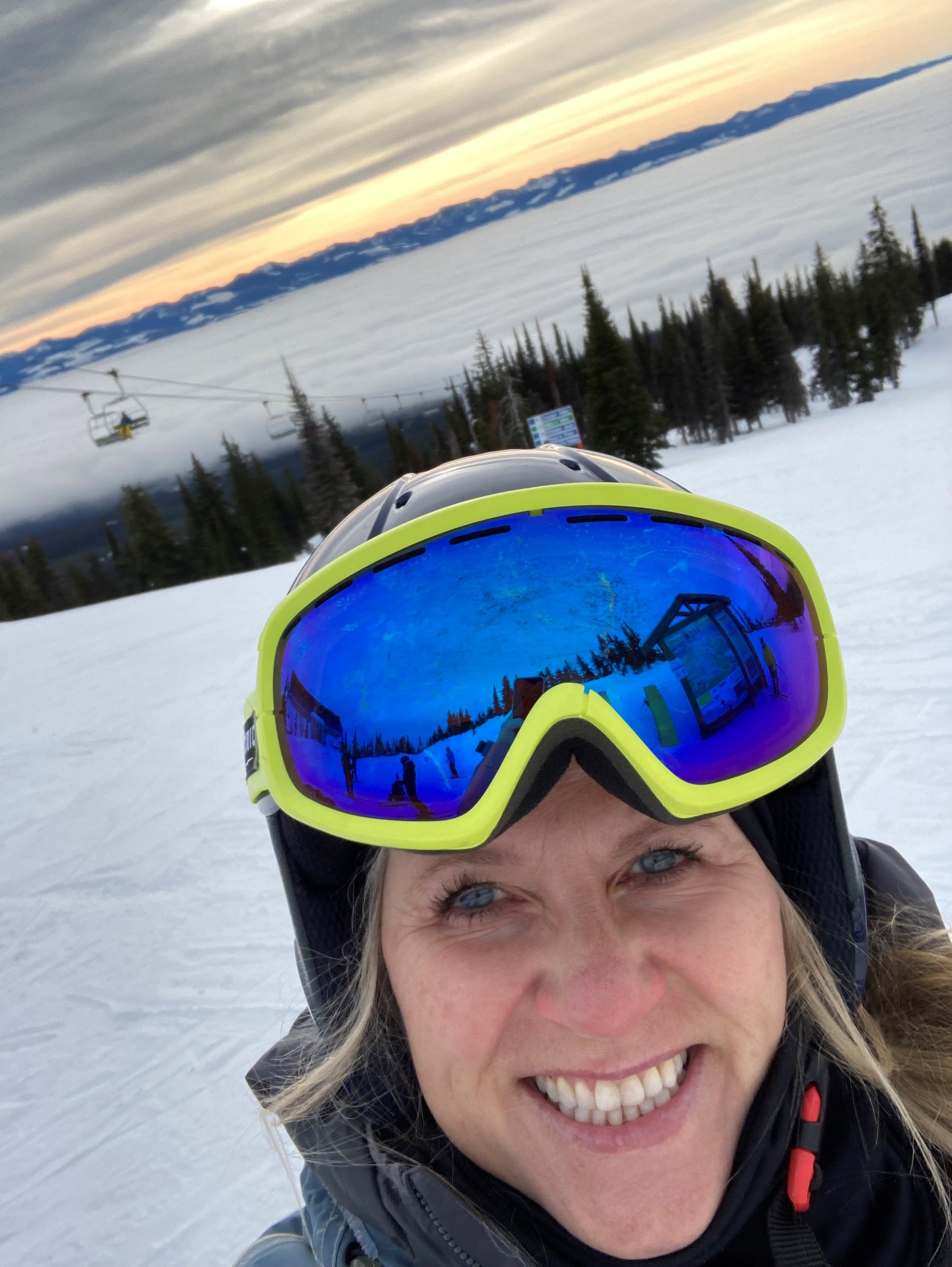 A women taking a selfie on top of a mountain in her ski gear