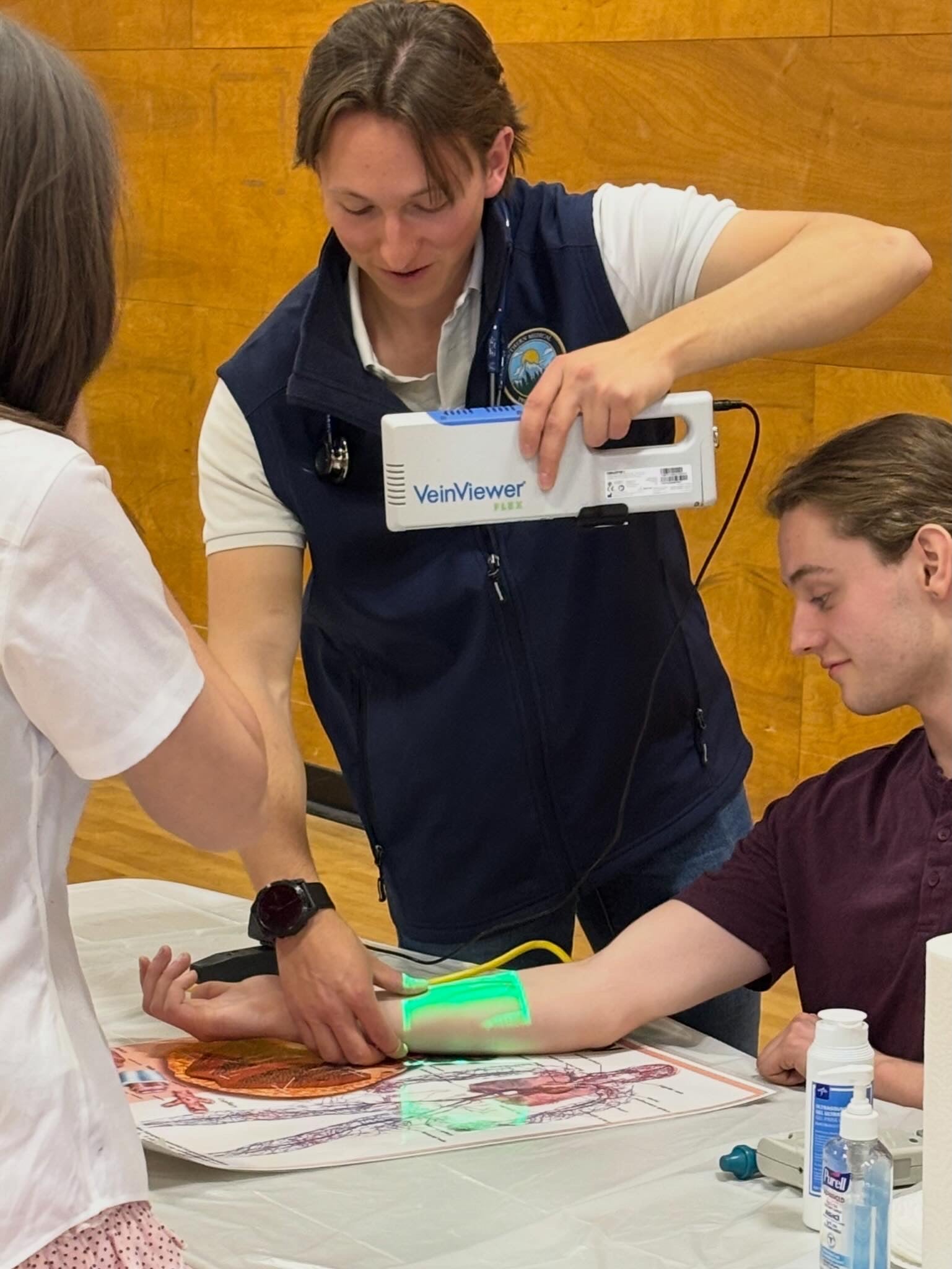 An instructor shows students how to use a piece of medical equipment.