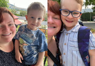 : A woman wearing a black top holding her young son, who is wearing a blue t-shirt, both looking at the camera in a selfie style.