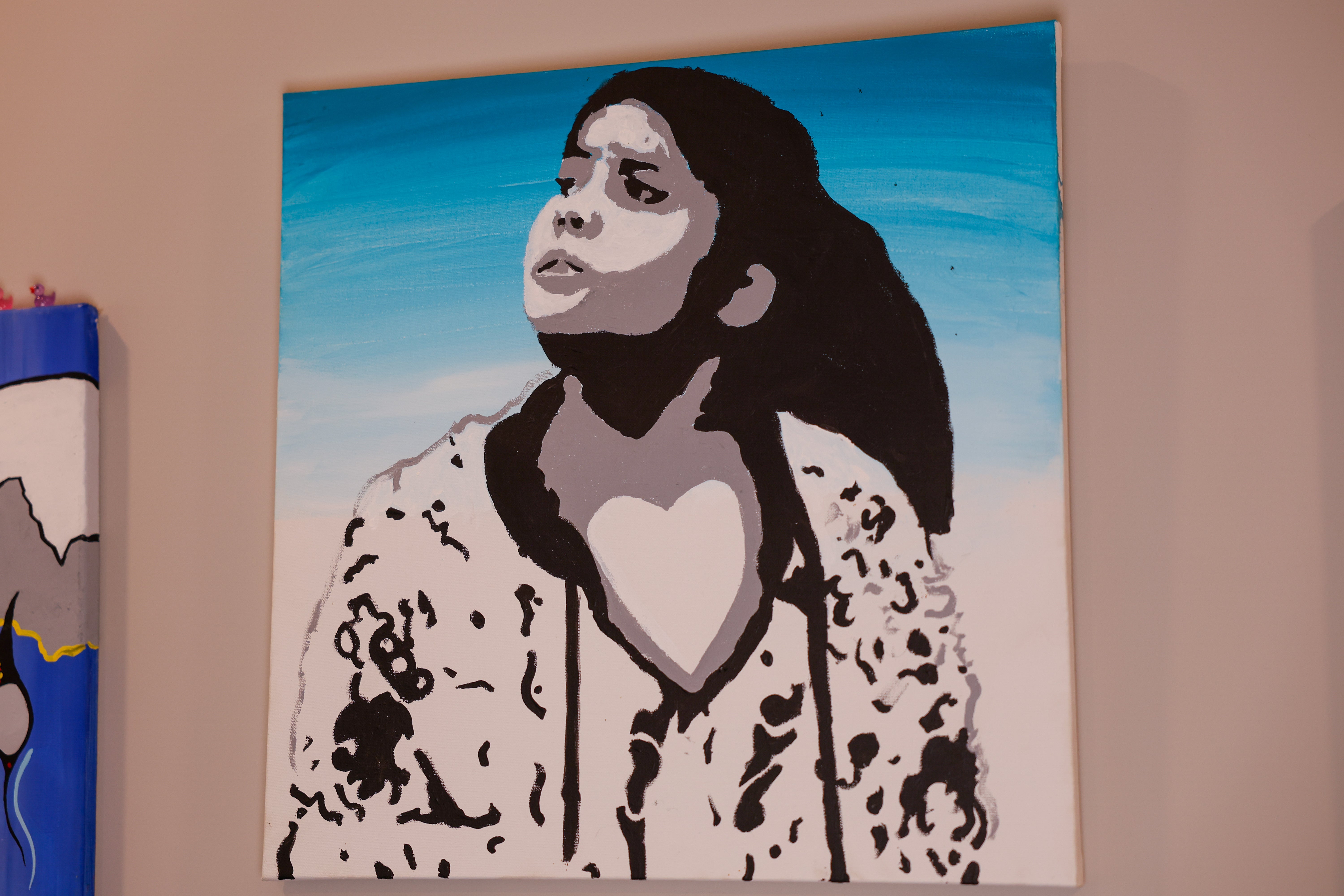 A blue, black, and white painting of a person looking into the distance.