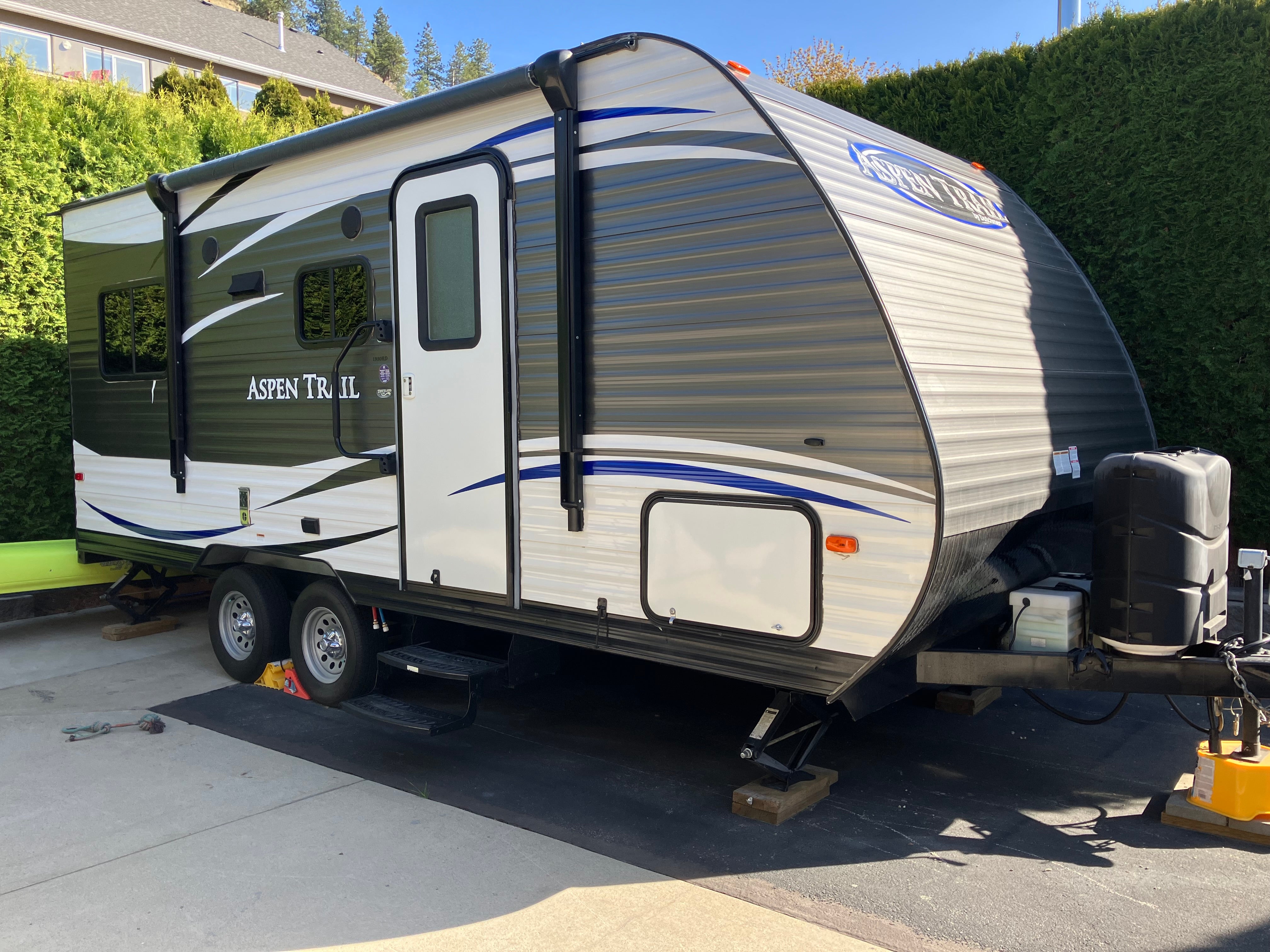 A medium-sized camping trailer parked in a driveway.