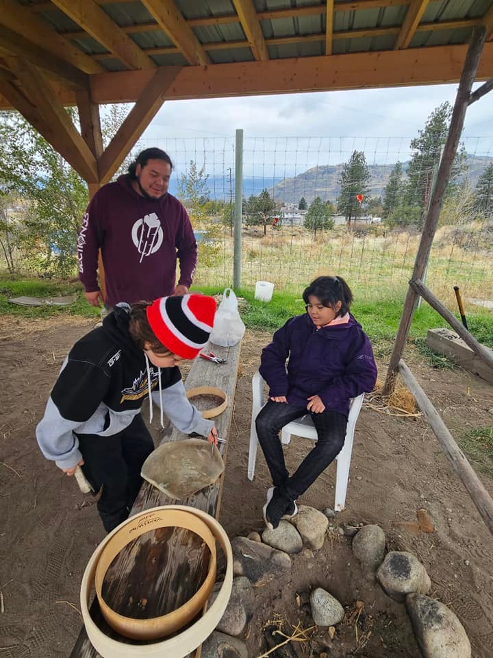 a group of people are outside making drums