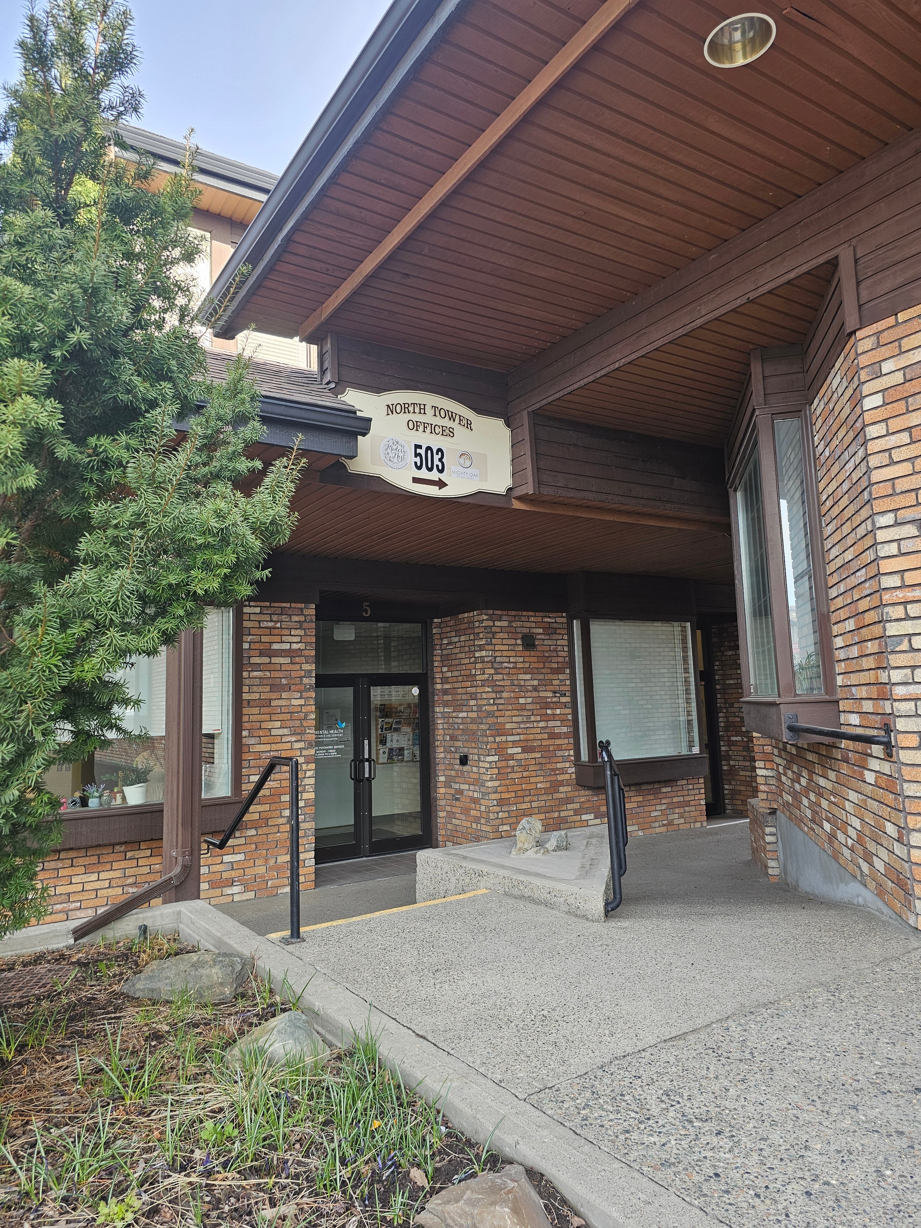 The front doors of a building surrounded by brick walls.