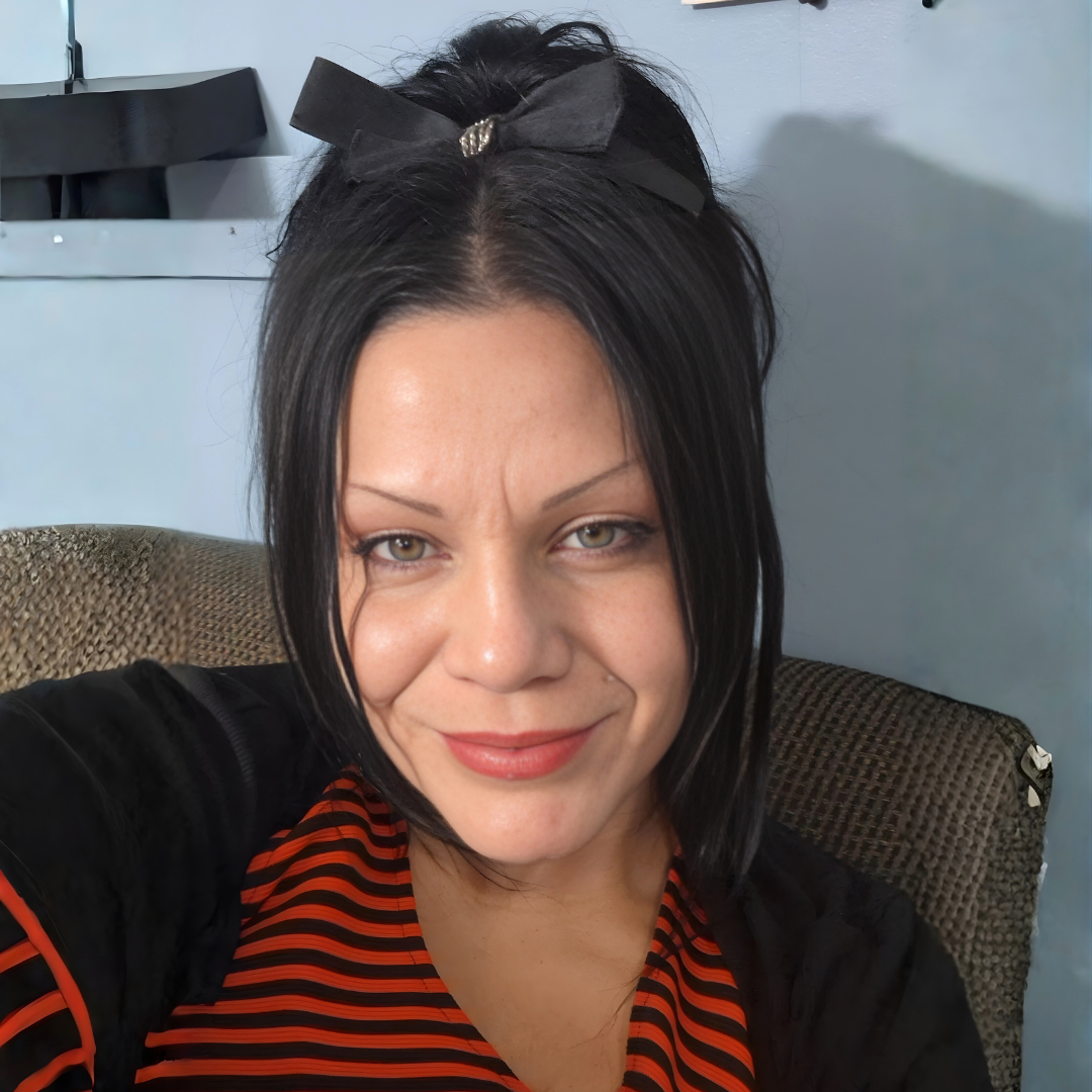 person with black hair and a red shirt smiles to camera