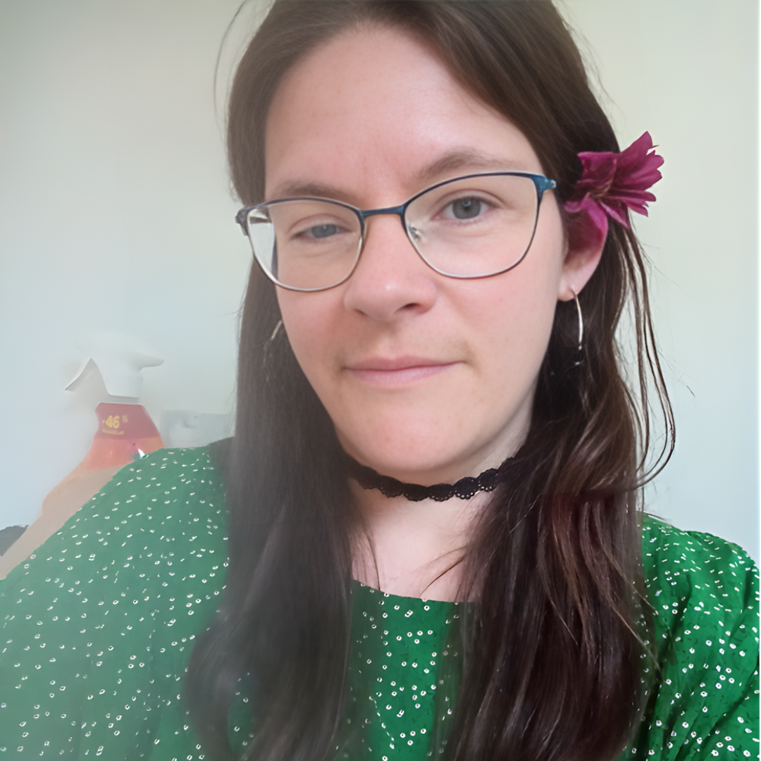 a person with brown hair wearing green and glasses