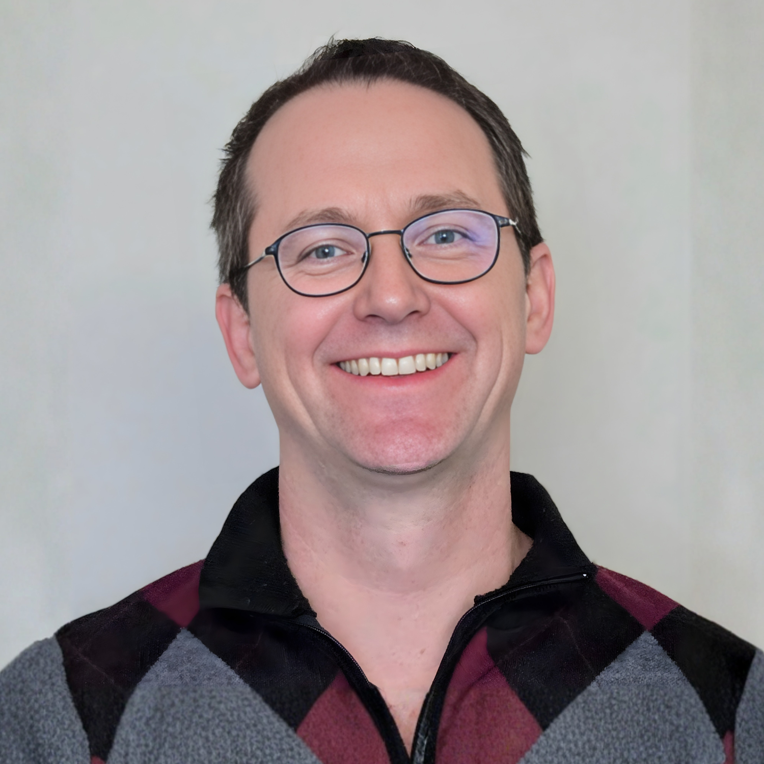 a person with glasses looks to camera