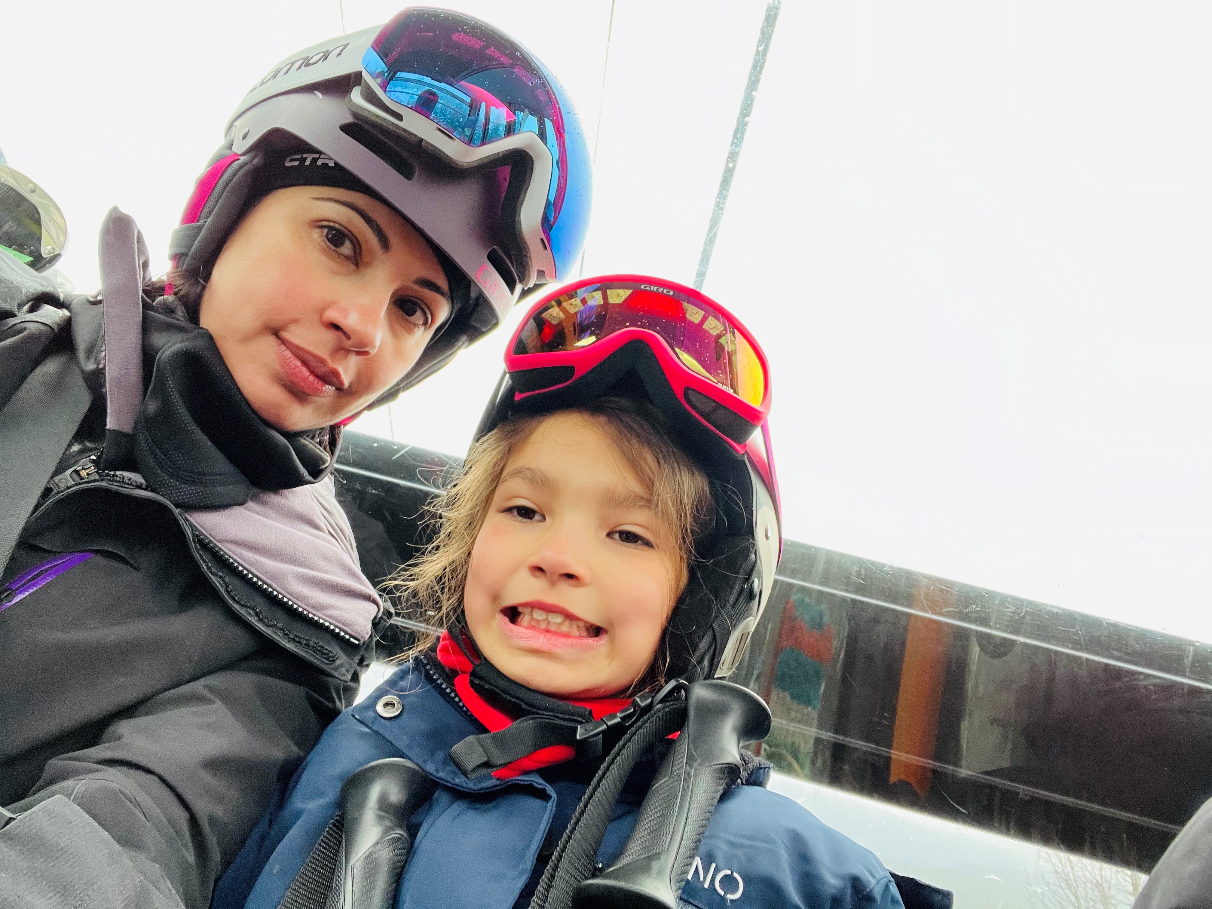 A selfie of a woman and child in skiing gear