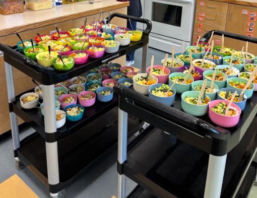 two wheeled dollies filled with dozens of pre poured soups in a kitchen