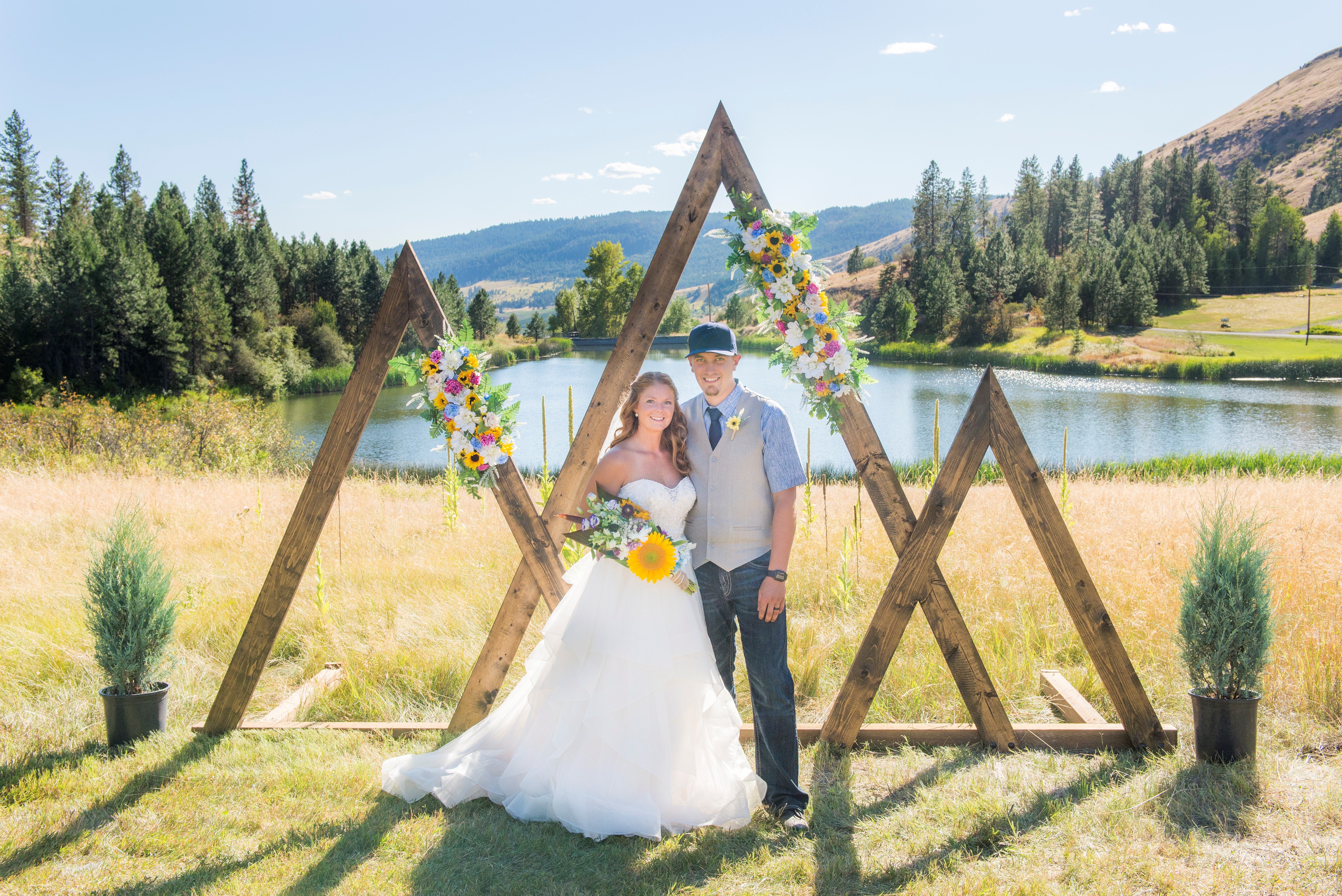 Bride and groom at wedding by lake and mountains.