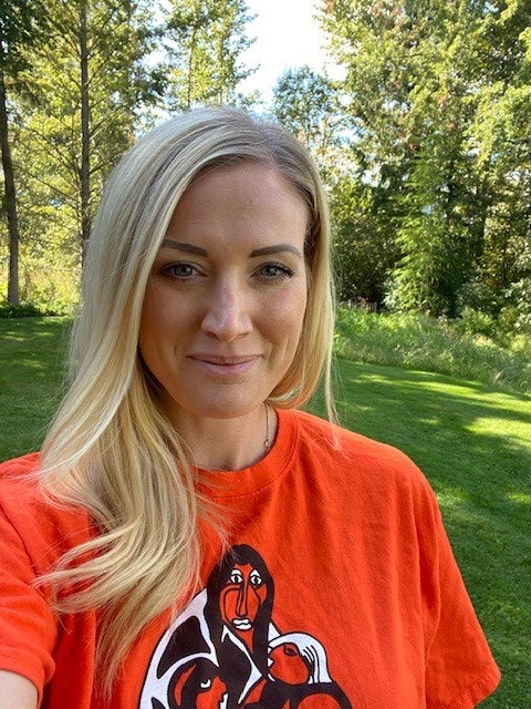 A woman wearing an orange shirt.