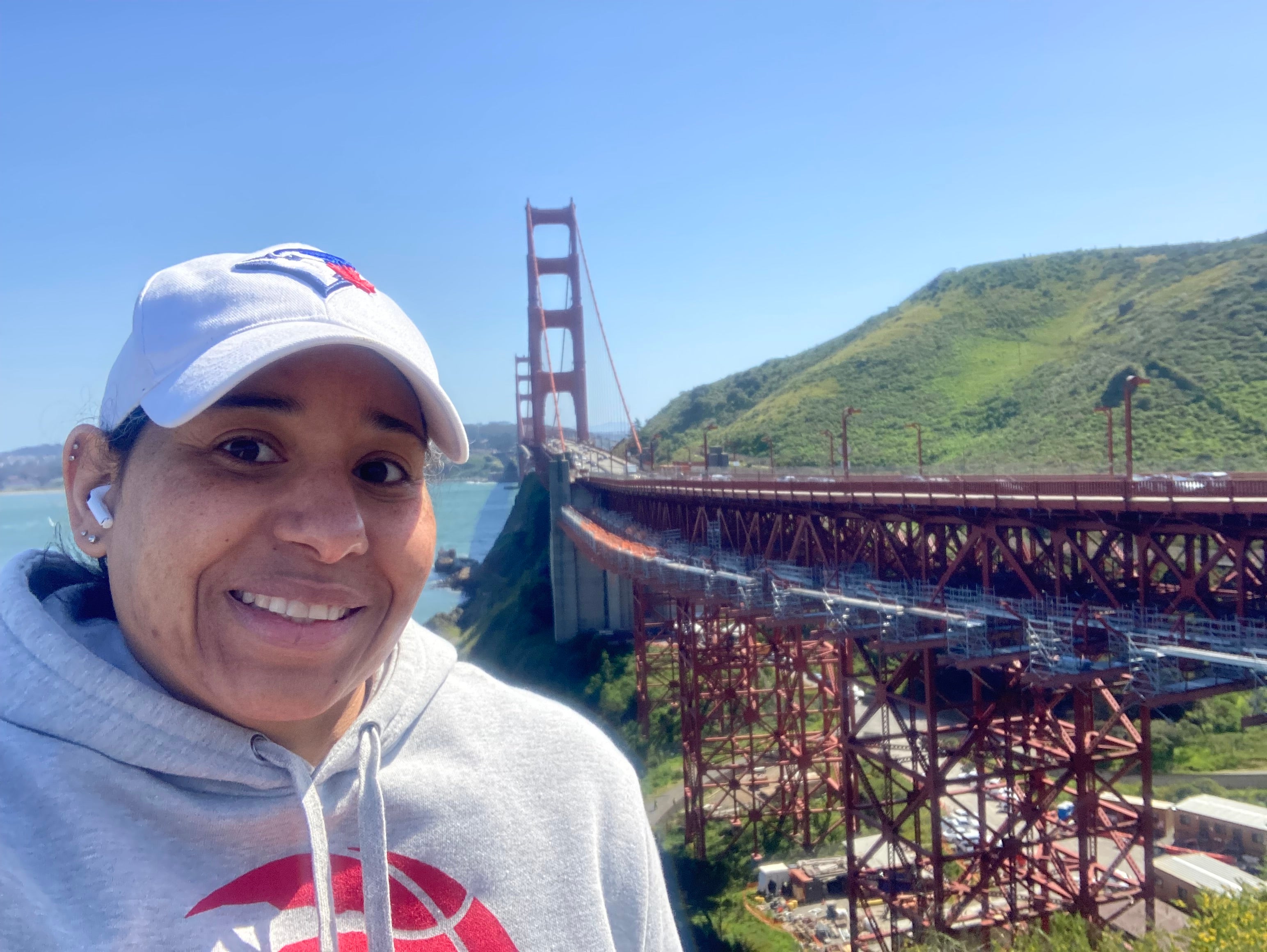 A Black woman smiling with the Golden Gate Bridge behind her