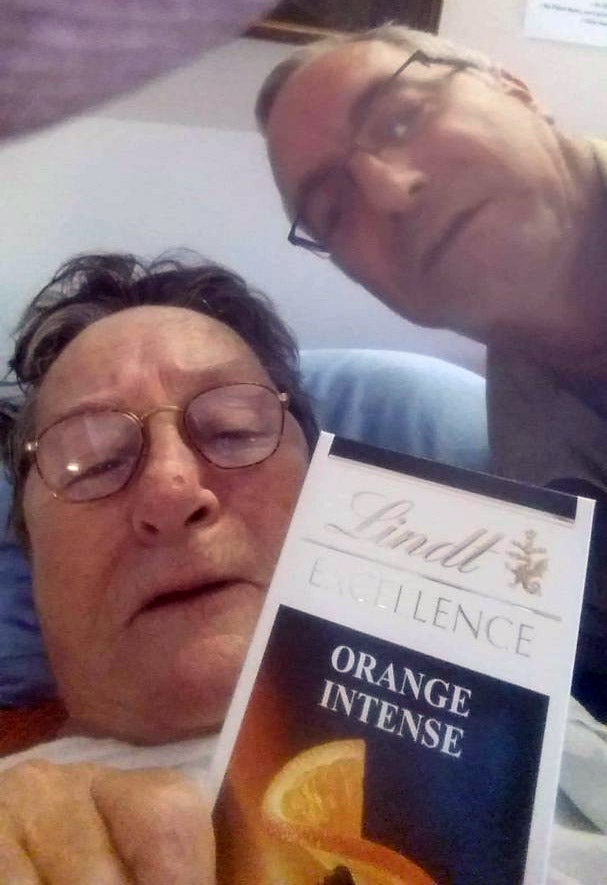 A selfie of two people, with a Lindt Orange Intense chocolate bar in the foreground.