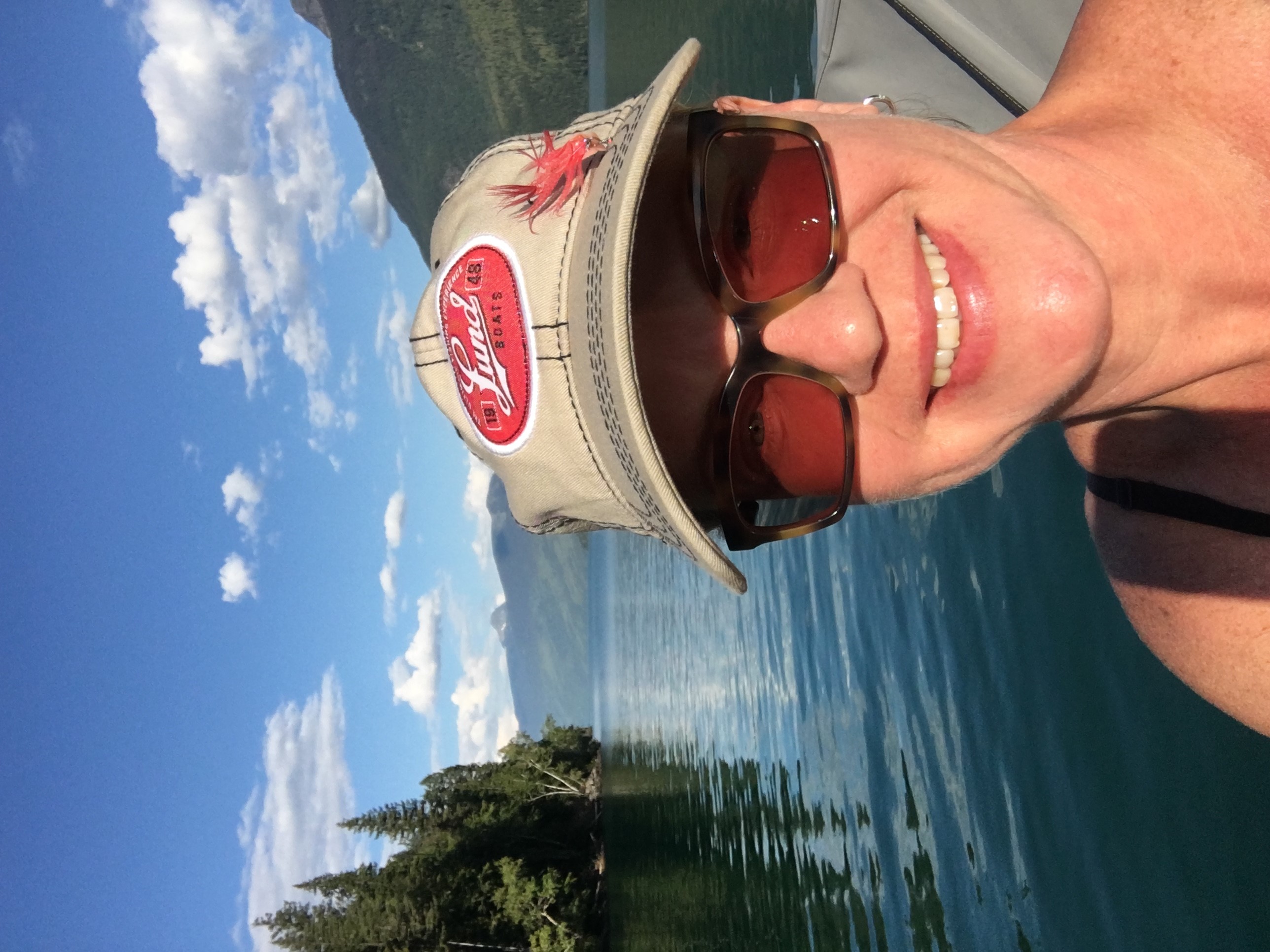 A woman takes a selfie during a sunny day on the lake. 