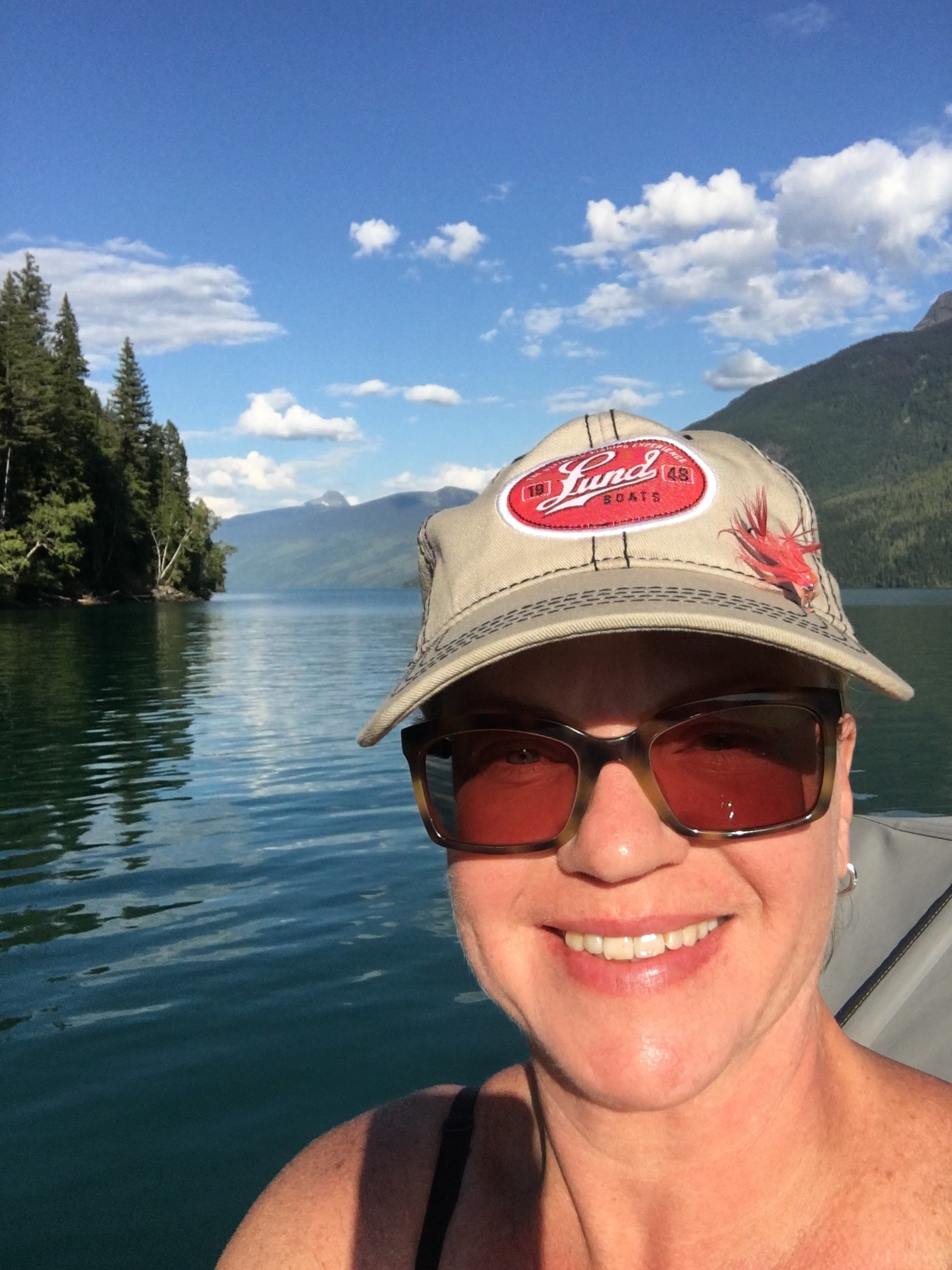 A woman takes a selfie during a sunny day on the lake. 