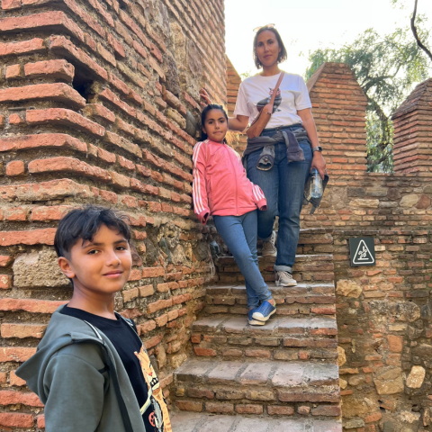 Woman standing on brick staircase with two children