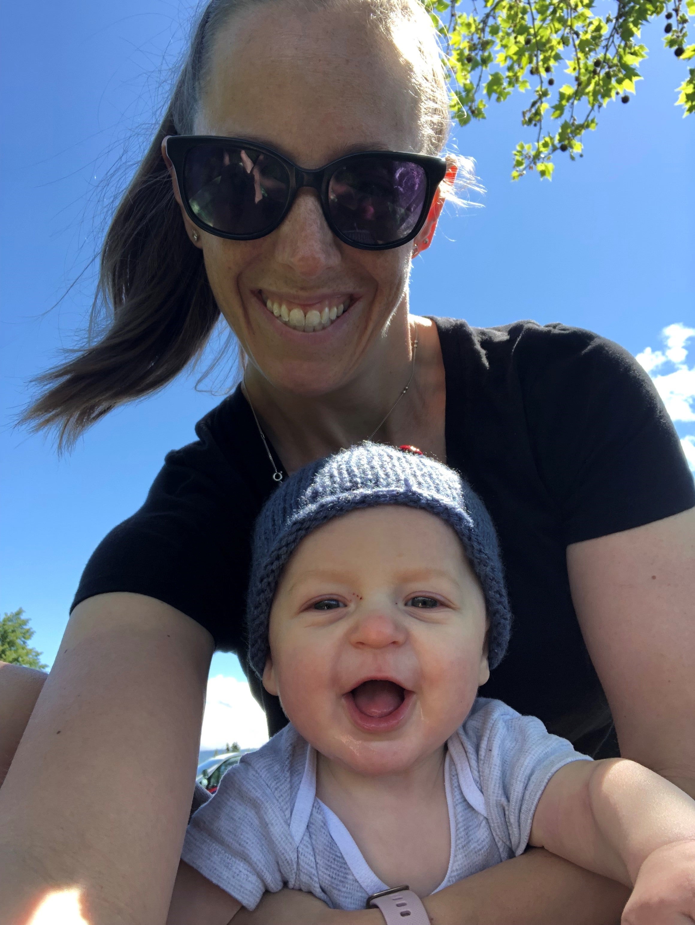 A smiling adult takes a selfie with an infant.