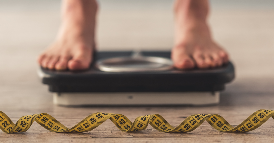 Feet on a scale, with a tape measurer in front.