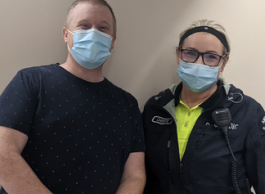 A male and female health-care worker posing for a picture.