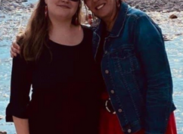 Two women standing by a river.