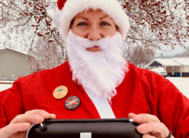 A person in a Santa Clause outfit holds a naloxone kit.