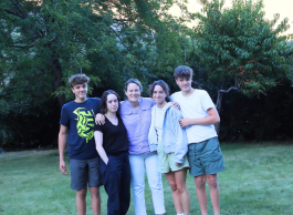 2 girl teens, 2 boy teens and one adult woman hug and pose outdoors facing the camera